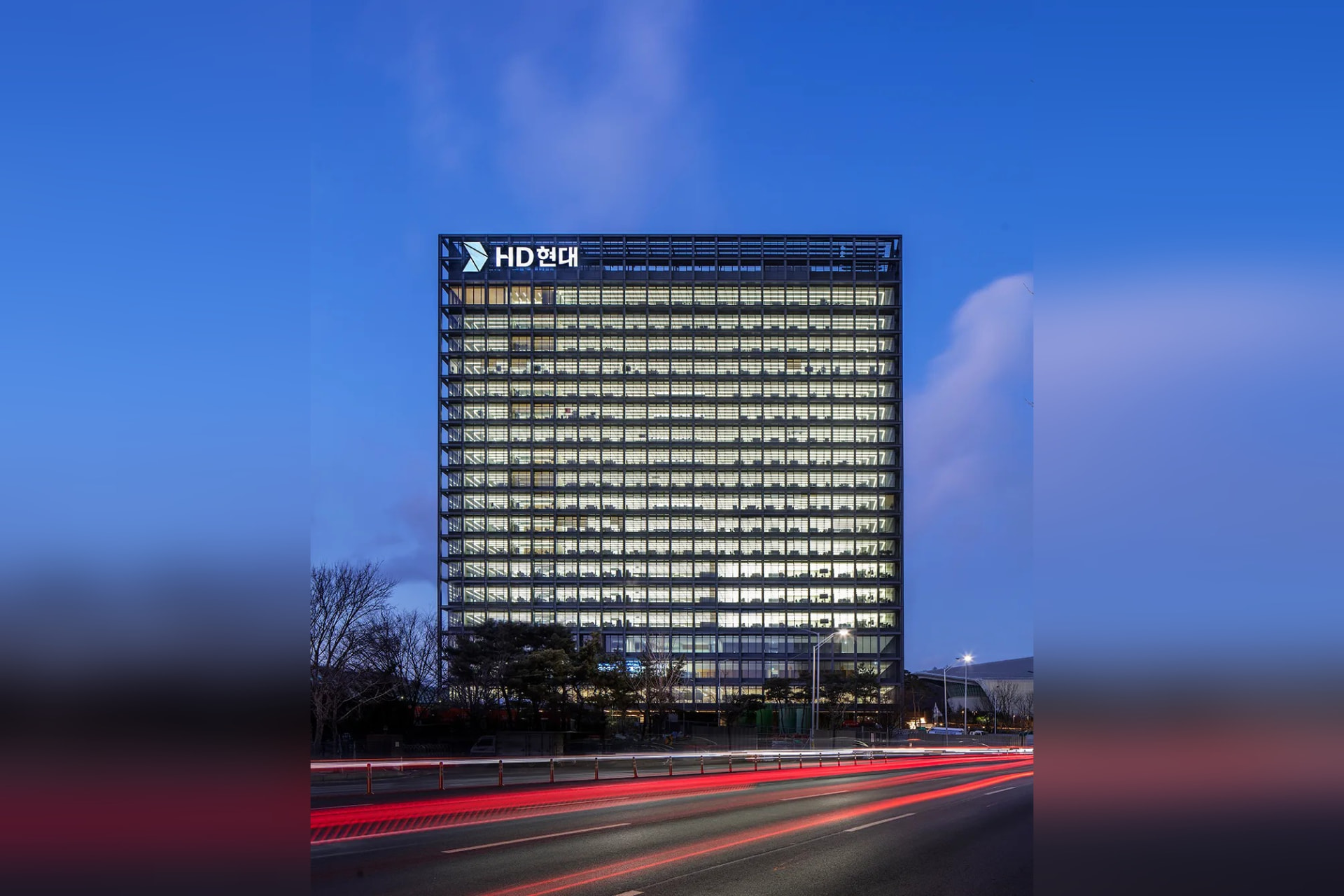 HD Hyundai global headquarters building illuminated at dusk